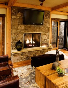 Log cabin fireplace design with mounted TV
